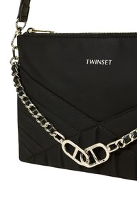 Borsa a tracolla nera in nylon con motivo trapuntato, tracolla a catena argentata e logo. Dotata di chiusura a zip e dettagli testurizzati.