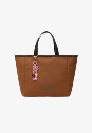 Borsa a tracolla marrone con manici neri, caratterizzata da un portachiavi con accenti rosa e neri, e un logo geometrico grigio sul davanti.
