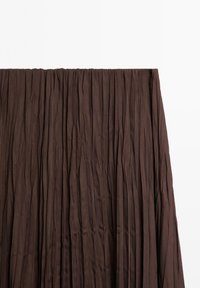 Tissu de jupe plissée brun foncé avec des plis verticaux et une texture lisse sur un fond blanc uni.