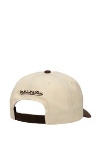 Krem kapa s tamnosmeđim vizirima i prilagodljivom trakom. Na zadnjoj strani je izvezen "Mitchell & Ness" u smešnom smešnom.