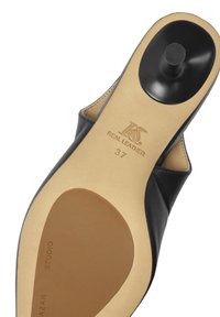 Semelle de chaussure en cuir noir avec un talon arrondi, présentant un intérieur beige, un label en relief "CUIR VÉRITABLE" et une taille 37. Texture lisse dans l'ensemble.