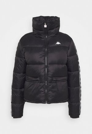 Veste matelassée noire avec col haut, fermeture éclair intégrale à l'avant, poches latérales et logo blanc sur la poitrine ainsi que des bandes sur les manches.