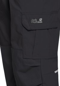 Μαύρο παντελόνι εξωτερικού χώρου με μεγάλη τσέπη με καπάκι που φέρει το λογότυπο Jack Wolfskin και αποτύπωμα πατούσας στο πάνω μέρος του μηρού.