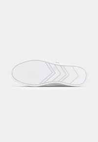 Suela de zapatilla blanca con una superficie de goma texturizada, que presenta un patrón de zigzag y surcos sutiles para el agarre. Punta redonda, diseño limpio.