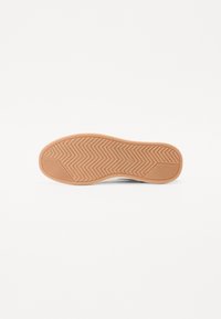 Sola de borracha castanha com um padrão de piso em zigzag, design plano, adequado para tração e durabilidade. Borda suave ao longo do perímetro.