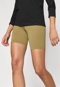 Khaki atletické šortky z elastickej látky, s hladkou textúrou, minimálnymi švami a priliehavým strihom nad kolenom.