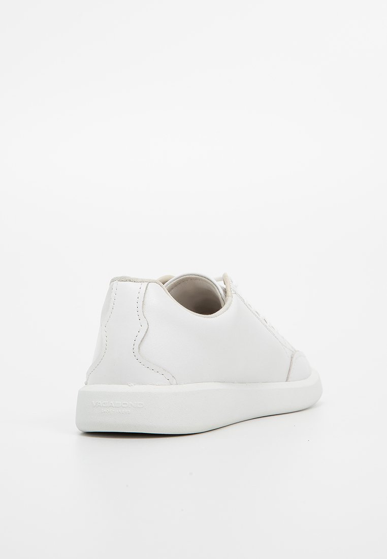 Baskets en cuir blanc présentant une silhouette basse, un bout rond et un design minimaliste. Texture douce avec des coutures discrètes et une semelle contrastante.