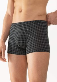 Boxers noirs en tissu doux, avec un motif géométrique gris. Le design offre une coupe confortable et une étiquette sur la ceinture.