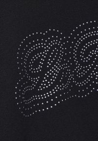 Fekete szövet, kis ezüst fém szegecsekből készült örvénylő mintával, sima tapintással és minimalista esztétikával.