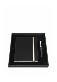 Carnet en cuir noir avec deux rayures verticales et stylo noir, tous deux soigneusement placés à l'intérieur d'une boîte de présentation noire assortie.