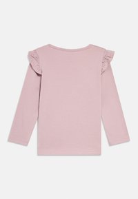 Różowa koszula z długim rękawem z marszczeniami na ramionach, wykonana z miękkiej, lekkiej bawełny; gładka faktura, prosty, okrągły dekolt.