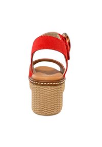 Sandale en suede rouge avec une haute plateforme en espadrille, dos ouvert et une large lanière avec un détail de boucle décoratif. Semelle intérieure rembourrée marron.