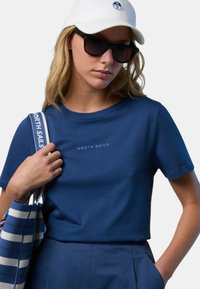 Maglietta in cotone blu navy con collo rotondo e maniche corte; presenta un piccolo logo "NORTH SAILS" in blu più chiaro sul petto.