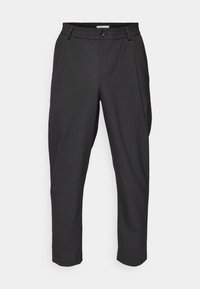 Svarta, avsmalnande byxor med elastisk midja, framfickor och enkel knappstängning. Slätt tyg med en subtil textur.