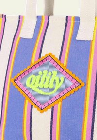 Borsa a tracolla in tessuto a righe con strisce blu, rosa e gialle. Presenta una patch ricamata a forma di diamante con la parola "qility" in verde neon.
