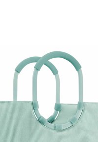 Mintgrüne Tasche mit gerippter Textur, ausgestattet mit zwei runden Griffen aus glattem, glänzendem Material. Die Griffe sind mit runden Akzenten verbunden.