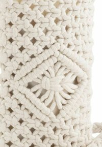 White, woven cotton macramé with a diamond pattern and textured detailing. Features intricate knots and an open, airy design.