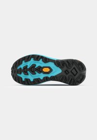 Suela Vibram negra y turquesa con surcos profundos y un acabado texturizado. Presenta un logo dorado en el centro.