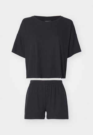 Fekete két részes otthoni viselet szett, amely egy rövid ujjú crop toppot és egy gombos elülső záródású, hozzáillő rövidnadrágot tartalmaz.