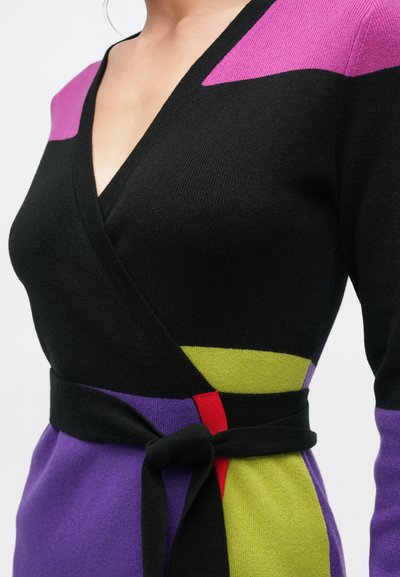 Μαύρο πλεκτό φόρεμα τύπου wrap με V-λαιμόκοψη, διακοσμημένο με πολύχρωμες ρίγες σε μωβ, πράσινο και κόκκινο. Λεπτομέρεια με ζώνη που δένει στη μέση ολοκληρώνει το σχέδιο.