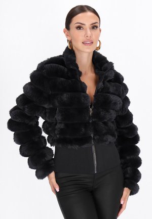 Schwarze Fake-Fur-gekürzte Jacke mit plüschigen, abgerundeten Streifen, geripptem schwarzen Bund und vorderem Reißverschluss. Glatte Textur, elegantes Design.