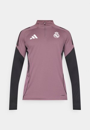 Bluză liliac deschis cu mâneci lungi, accente negre, guler cu fermoar de un sfert, cu un logo pe piept și material texturat subtil.