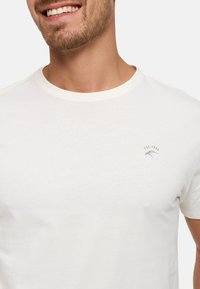 Kurzärmliges weißes Baumwoll-T-Shirt mit Rundhalsausschnitt. Verfügt über ein kleines, graues Logo mit "EST. 1993" auf der linken Brustseite.