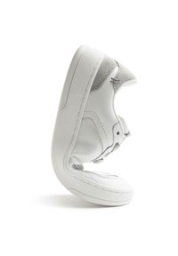 Sneaker in pelle bianca con punta arrotondata, dettagli in suede, cuciture evidenti e colletto imbottito. La suola ha un profilo piatto.