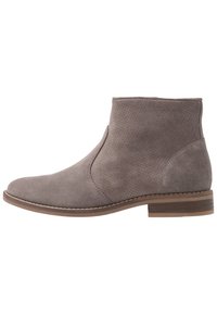 Gray suede ankle boot with a smooth texture, slight heel, and minimalist design. Features a rounded toe and subtle stitching accents.