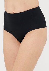 Woman wearing high-waist black seamless underwear, showing midsection and upper thighs against a plain background.