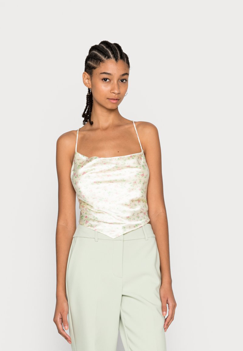 Camisola de cetim floral em verde suave e branco, com alças finas e um corte descontraído, combinada com calças ajustadas em verde claro.