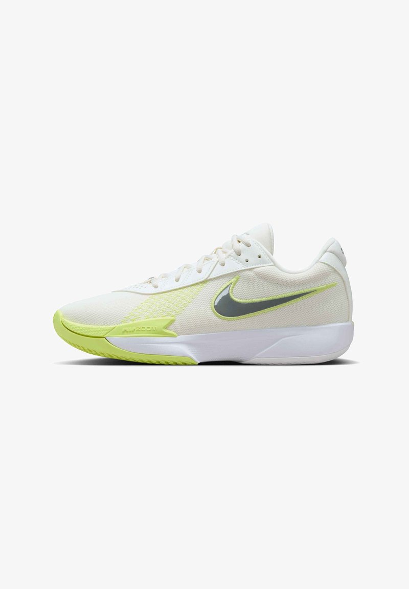 Hvid atletisk sko med en struktureret overdel, der har en limegrøn sål og detaljer samt et gråt Nike-logo på siden.