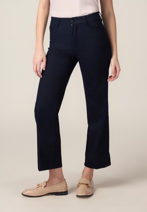Pantaloni in denim blu navy scuro con vestibilità a gamba dritta, caratterizzati da piccoli dettagli metallici e una chiusura classica con bottone.