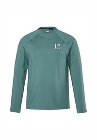Pitkähihaisen tee paidan teal-väristä kangasta, jossa on pyöreä kaula-aukko, raglan-hihat ja valkoinen logo rinnassa. Sujuva rakenne, kevyt muotoilu.