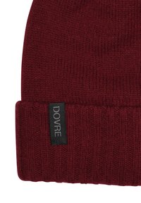 Bordeaux strik beanie med ribbet tekstur og sort stofmærke, der viser "DOVRE." Den nederste kant har en dobbeltfoldet manchet.