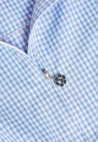 Lys blå og hvide ginghamstof med en sølvlynlås, der har en blomstformet lynlåstrækker. Glat tekstur, pænt syede kanter.