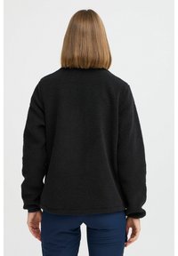 Veste en polaire noire avec un extérieur texturé et doux. Dotée d'un col arrondi et de manches longues, avec un ourlet uniforme à la taille.