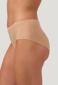 Beige högmidjade trosor gjorda av mjukt, elastiskt material, med en sömlös design och minimalistiska kanter för komfort och diskret användning.