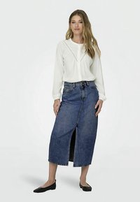 White long-sleeve blouse with lace details, paired with a dark denim midi skirt featuring a front slit and classic denim texture. Black flats complete the look.