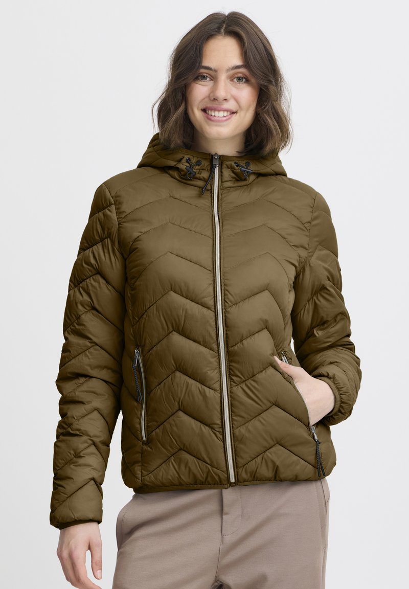 Alyvuogių žalios spalvos pūstinė striukė su gobtuvu, dekoruota chevrono formos siuvinėjimu, dviem šoniniais užtrauktukų kišenėmis ir reguliuojamais raišteliais prie gobtuvo.