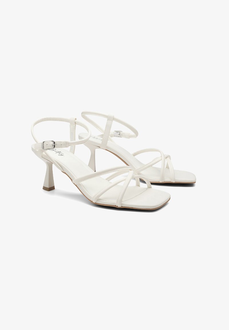 White strappy sandals with a square toe and a block heel, featuring a thin ankle strap and smooth synthetic material.