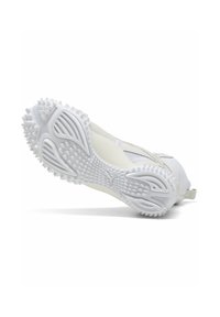 White athletic shoe angled to show textured sole with spikes and Puma logo on a plain white background.