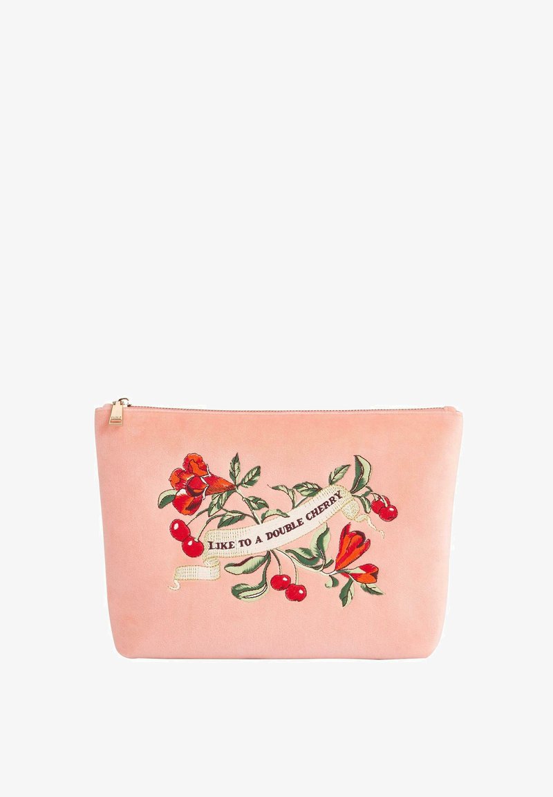 Vaaleanpunainen, mokkapussi, jossa on brodeerattuja punaisia kukkia ja kirsikoita, sekä koristeellinen nauha, jossa lukee "SEKOITA KAKSI KIRSIKKAa." Kultainen vetoketju.