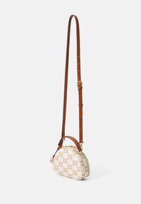 Krosbodi taška s krémově barevným rámem a opakovaným logem v béžové barvě. Hnědý kožený popruh a akcenty. Zlaté kovové detaily.