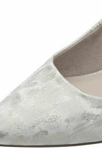Chaussure en tissu gris clair avec un bout pointu, présentant une texture florale subtile et une doublure intérieure lisse et mate.