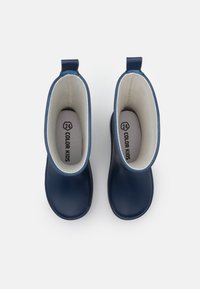 Marinblå gummistövlar med slät yta, ljusgrå foder, dragflikar och storlek 24-märke på innersulan. Har rund tåform.