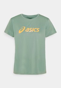 Vaaleanpunainen lyhythihainen t-paita pehmeää kangasta, jossa on suuri keltainen ASICS-logo keskitettynä etuosassa. Pyöreä kaula-aukko.