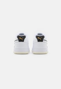 Hvide sneakers med sorte teksturerede hælindlæg, guld logo, gummisål og polstret krave; minimalistisk design med syede detaljer.