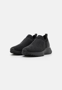 Czarne wsuwane sneakerki wykonane z teksturowanej dzianiny z trwałą gumową podeszwą i uchwytem z tyłu, ułatwiającym zakładanie.