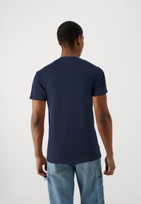 Marineblå bomull t-skjorte med rund hals, korte ermer og en figursydd silhuett. Stoffet ser jevnt og lett ut.